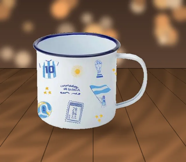 Jarrito enlozado con ilustraciones, sobre la mesa de madera de un café